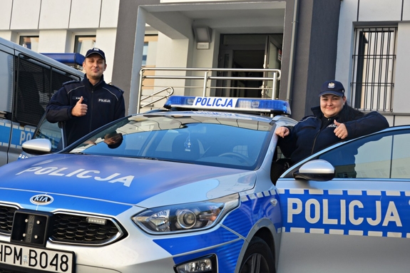 Policjanci przy radiowozie.