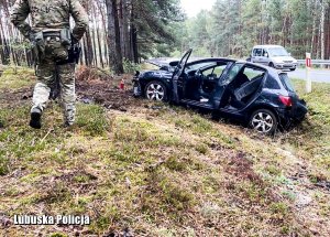 Zniszczone w wypadku auto przy leśnej drodze