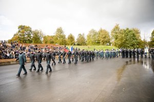 defilujący policjanci, po lewej stronie trybuny