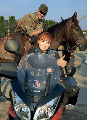 W tle policjant na koniu, na pierwszym planie motocyklistka z referatu koni w Szczecinie, członkini Blue Knights Poland.