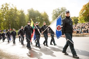 Policyjna defilada - umundurowani litewscy policjanci, którzy idą z przodu, niosą sztandary
