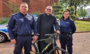 policjant i policjantka oraz ksiądz z odzyskanym rowerem