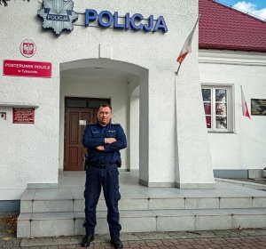 Umundurowany policjant stoi przed budynkiem Policji w Tykocinie