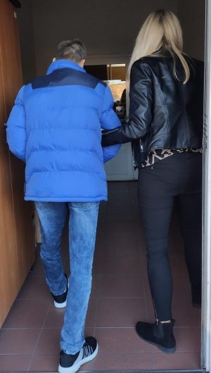 Policjantka prowadzi zatrzymanego