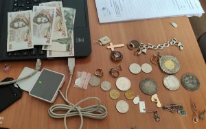 Zabezpieczona przez policjantów gotówka i pieniądze rozłożone na stole
