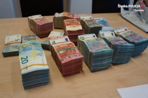 na stole leży kilka plików banknotów spiętych gumką recepturką