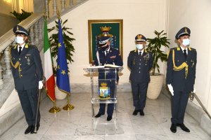 umundurowany polski generał Policji wpisuje się do księgi pamiątkowej, obok niego stoi włoski umundurowany generał Policji, a z przodu warte trzymają dwaj umundurowani włoscy policjanci z szablami w lewej dłoni