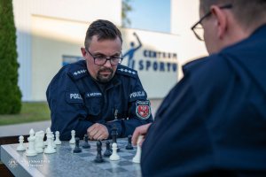 dwaj umundurowani policjanci przy stoliku grają w szachy