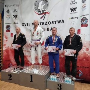 czterej zawodnicy na podium z medalami na szyi, w rękach trzymają dyplomy