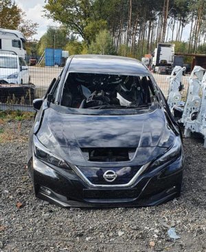 miejsce ujawnienia przez policjantów podzespołów samochodowych pochodzących z kradzieży, na pierwszym planie częściowo zdekompletowany elektryczny nissan leaf