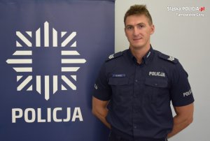 umundurowany dzielnicowy pozuje do zdjęcia