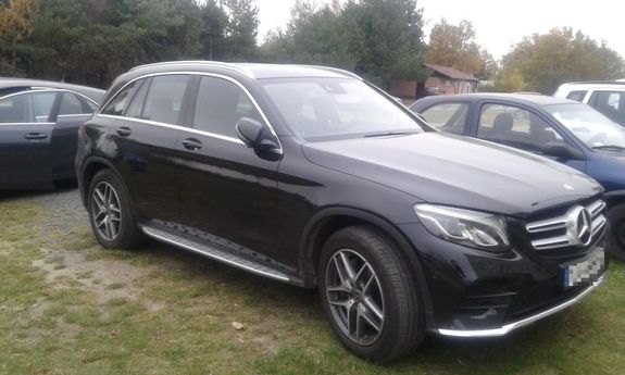 czarny mercedes stojący na parkingu wśród innych aut