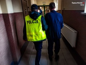 policjant prowadzi zatrzymanego mężczyznę