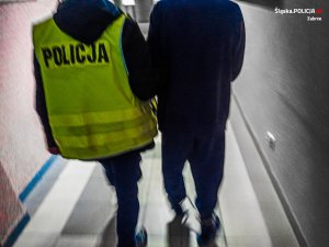 policjant prowadzi zatrzymanego mężczyznę