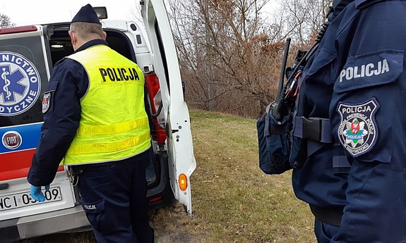 policjanci stoją przy karetce pogotowia