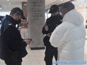 policjanci rozmawiają z zatrzymanym mężczyzną