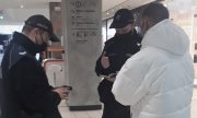 policjanci rozmawiają z zatrzymanym mężczyzną