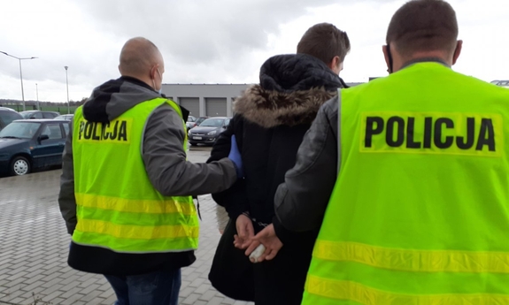 Zatrzymany mężczyzna prowadzony przez policjantów