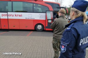 policjantka stoi w kolejce do krwiobusu