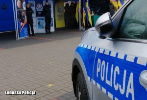 bok radiowozu, w tle stojące policjantki