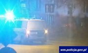 radiowóz policyjny z włączonymi sygnałami świetlnymi stojący na ulicy