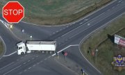 ujęcie z drona, na którym widać samochód ciężarowy na drodze, znak STOP, logo opolskiej Policji