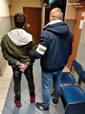 policjant trzyma podejrzanego mężczyznę