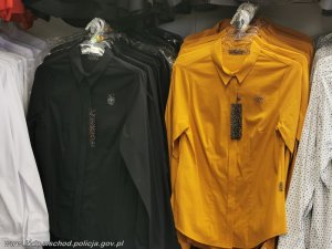 Koszule w kolorze czarnym i musztardowym wiszą na wieszakach