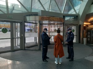 dwaj policjanci z kobietą w centrum handlowym