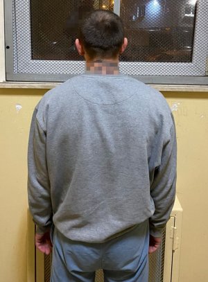 zatrzymany stoi w celi odwrócony plecami