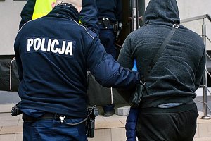 policjant prowadzi zatrzymanego