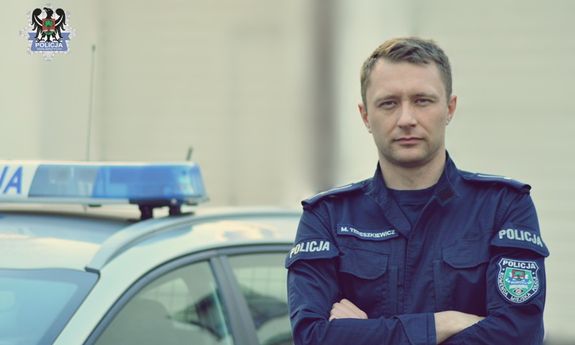 policjant stojący obok radiowozu