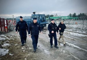 czterech oficerów idzie obok siebie, jeden w mundurze kontrterrorysty