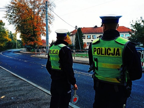 dwóch policjantów ruchu drogowego stoi przy jezdni