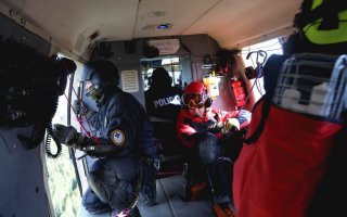 Dwaj ratownicy TOPR oraz dwaj policjanci podczas lotu śmigłowcem