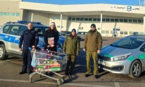 Policjanci oraz funkcjonariusze Straży Granicznej oraz osoby cywilne stojące przed samochodami