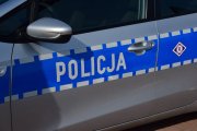 napis Policja na drzwiach policyjnego radiowozu