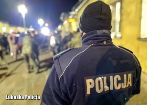 Policjant stojący przed grupą mężczyzn