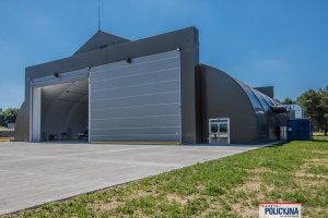 Hangar z częściowo otwartymi drzwiami.