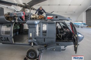 Policyjny technik dokonuje inspekcji silnika śmigłowca Black Hawk.