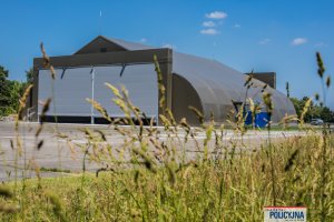 Hangar policyjnych śmigłowców i fragment płyty lotniska.