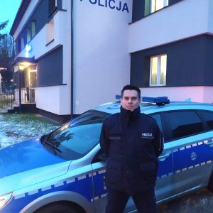 policjant stojący przed radiowozem