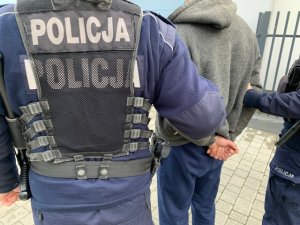 policjanci prowadzą zatrzymanego mężczyznę