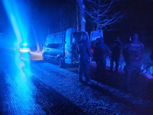 Bus stoi na drodze,  obok stoją policjanci