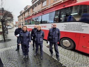 policjanci w mundurach stojący przy krwiobusie