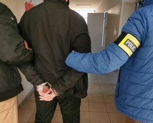 policjanci trzymają zatrzymanego mężczyznę