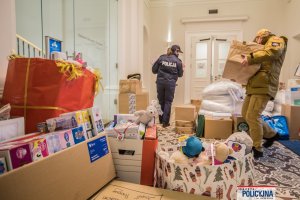 policjantka i strażnik graniczny z paczkami na rękach, na podłodze paczki