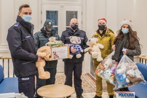 czterej mężczyźni w mundurach i kobieta z paczkami dla dzieci w sali szpitalnej