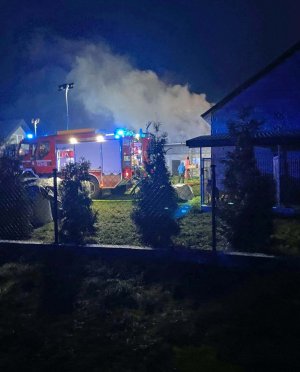 Płonący budynek i wóz straży pożarnej