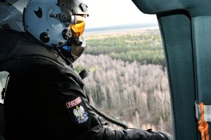 policyjny lotnik z pokładu śmigłowca obserwuje okolicę